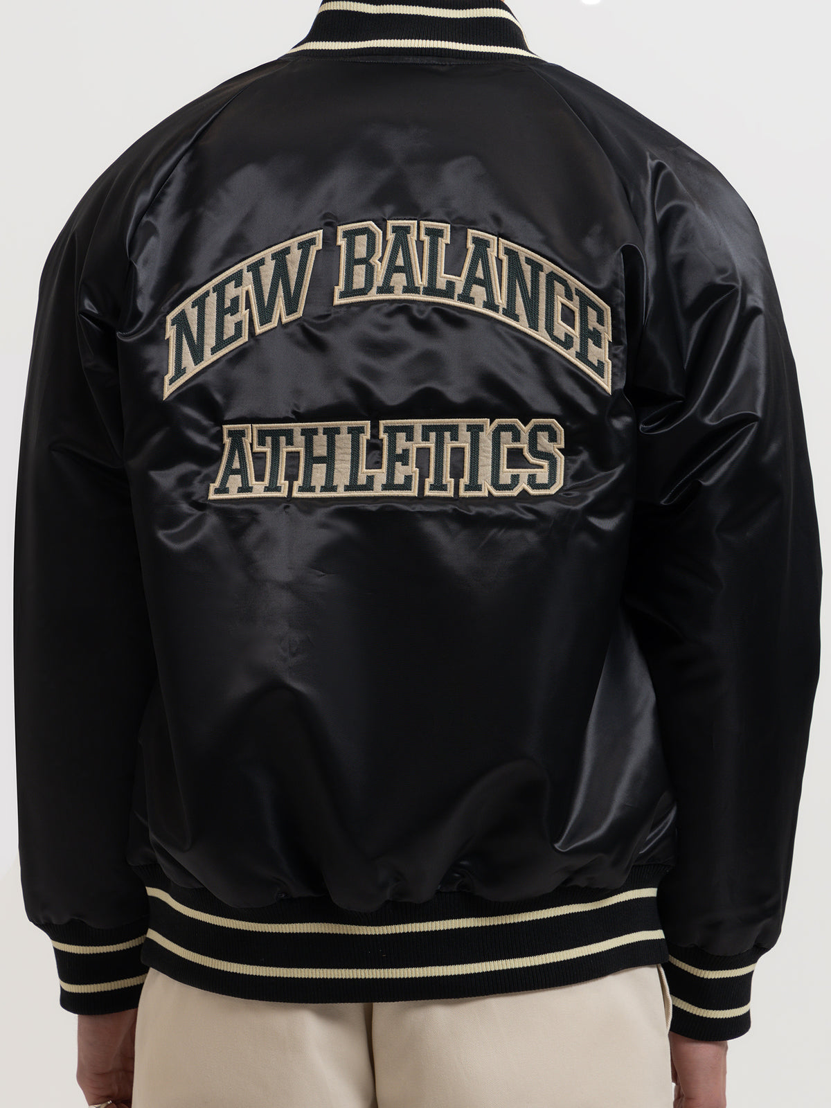 New Balance Athletics Varsity Satin Bomber Jacket in Black | Black