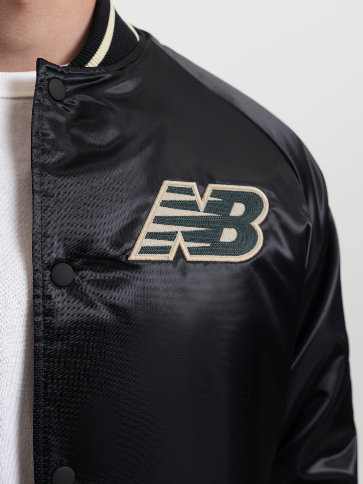 New Balance Athletics Varsity Satin Bomber Jacket in Black | Black